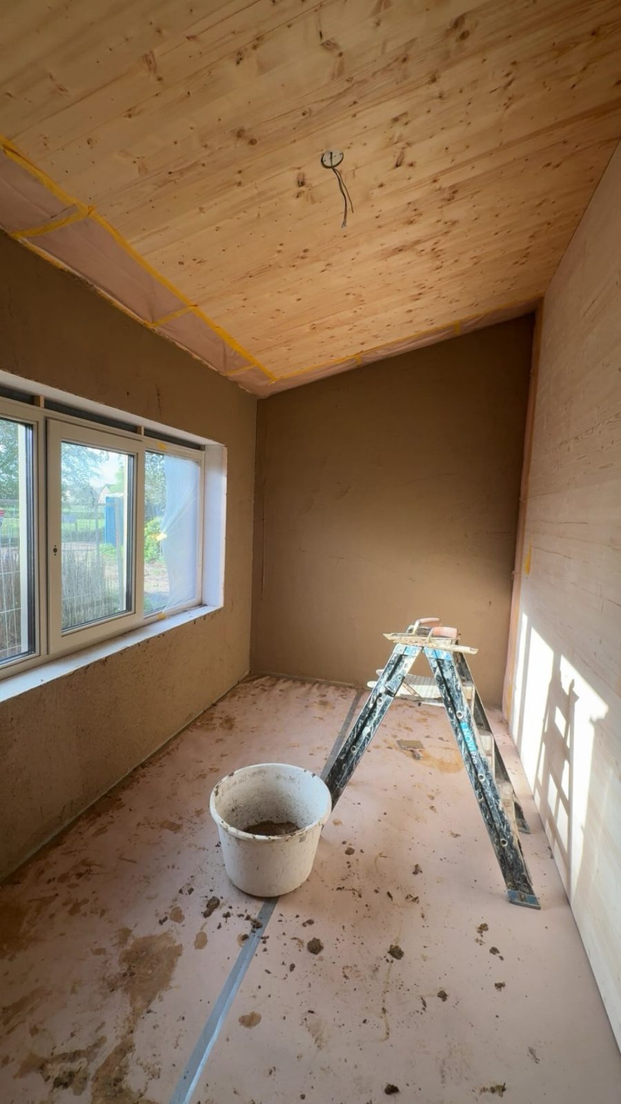 Kamer met vers aangebracht leemstuc op de wanden en een houten plafond